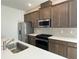 Well-appointed kitchen showcasing a large island, stainless steel appliances, and stylish backsplash at 27469 Black Kite Ave, Howey In The Hills, FL 34737