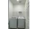 Functional laundry room with a white washer and dryer, complemented by a wire shelf for added storage at 27469 Black Kite Ave, Howey In The Hills, FL 34737