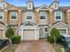 Tan two-story townhome with stone accents and a two-car garage at 3196 Crown Jewel Ct, Winter Park, FL 32792