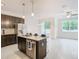 Modern kitchen with dark cabinetry, granite countertops, stainless steel appliances, and island at 3196 Crown Jewel Ct, Winter Park, FL 32792