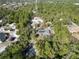 Aerial view of a house with solar panels and a pool, surrounded by trees at 3290 Red Fox Dr, Deltona, FL 32725