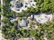 Aerial view of a house with solar panels, pool, and detached garage, surrounded by lush greenery at 3290 Red Fox Dr, Deltona, FL 32725