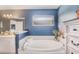 Relaxing bathroom with soaking tub, updated vanity, and soothing blue walls at 3290 Red Fox Dr, Deltona, FL 32725