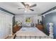 Cozy bedroom with double bed, wooden dresser, and ceiling fan at 3290 Red Fox Dr, Deltona, FL 32725