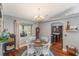 Bright dining room features a round wooden table with white chairs, hardwood floors, and a view to the kitchen at 3290 Red Fox Dr, Deltona, FL 32725