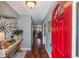 Inviting entryway with red door opening to hardwood floors and living area at 3290 Red Fox Dr, Deltona, FL 32725