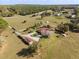 Overhead view of the property showing the home, acreage, detached garage, trampoline, and playground at 36129 E Eldorado Lake Dr, Eustis, FL 32736