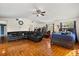 Spacious living room featuring a black leather sectional sofa and warm wood floors at 36129 E Eldorado Lake Dr, Eustis, FL 32736