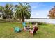 Lakefront backyard with fire pit and colorful Adirondack chairs at 41235 Silver Dr, Umatilla, FL 32784