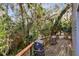 Back deck with grill and surrounding lush greenery at 41235 Silver Dr, Umatilla, FL 32784