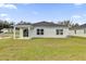 Spacious backyard view showing an exterior elevation with a covered patio and lush green lawn at 5571 Creek Haven Way, Lakeland, FL 33810