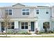 Two-story light blue townhome with gray accents and landscaping at 627 Bayhawk St, Debary, FL 32713