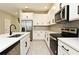 Modern kitchen with white cabinets, stainless steel appliances, and quartz countertops at 627 Bayhawk St, Debary, FL 32713