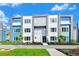 Modern three-story townhome with blue and gray siding, and walkway at 7740 Sandy Ridge Dr # 111, Reunion, FL 34747