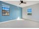 Bedroom with blue accent wall, ceiling fan, and two windows at 10389 Henbury St, Orlando, FL 32832