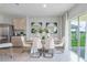 Modern dining area with white chairs and a view of the backyard at 1260 Big Bass Dr, Ormond Beach, FL 32174