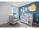 Charming bedroom with a blue accent wall and crib at 1264 Big Bass Dr, Ormond Beach, FL 32174