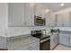 Modern kitchen with gray cabinets, stainless steel appliances, and granite countertops at 1331 Foran Manor Rd, Haines City, FL 33844