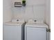 Bright laundry room with washer and dryer and overhead shelving at 1331 Foran Manor Rd, Haines City, FL 33844