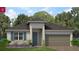 Charming single-story home with a two-car garage, a cozy front porch, and beautifully landscaped front yard at 1343 Foran Manor Rd, Haines City, FL 33844