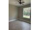 Cozy bedroom featuring a ceiling fan, neutral paint, and a view of the landscaped backyard at 1360 Jayce Ct, Geneva, FL 32732