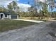 A single-Gathering home boasting a paved driveway, two-car garage, and a manicured lawn surrounded by trees at 1360 Jayce Ct, Geneva, FL 32732