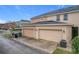 Two-car garage with beige doors and exterior lighting at 13651 Eridanus Dr, Orlando, FL 32828