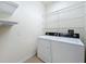 Bright laundry room with washer, dryer, and ample shelving at 13651 Eridanus Dr, Orlando, FL 32828