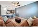 Living room with brown sectional sofa, hardwood floors, and a view of the kitchen at 13651 Eridanus Dr, Orlando, FL 32828