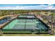 Two tennis courts with seating area and surrounding landscape at 13651 Eridanus Dr, Orlando, FL 32828