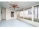 Spacious screened porch with light blue flooring and ceiling fan at 1401 W Highway 50 # 68, Clermont, FL 34711