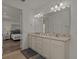 Double vanity bathroom with granite countertop and a large mirror at 1472 Fairview Cir, Reunion, FL 34747