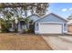 Light blue house with white garage door and landscaping at 148 Imperial Oak Ct, Davenport, FL 33896