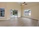 Bright Gathering room featuring vinyl plank flooring, sliding glass doors to pool area, and a ceiling fan at 148 Imperial Oak Ct, Davenport, FL 33896