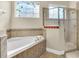 Bathroom with corner soaking tub, shower, and stained glass window at 1580 Prairie Oaks Dr, St Cloud, FL 34771