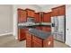 Spacious kitchen with island, stainless steel appliances, and wood cabinets at 1580 Prairie Oaks Dr, St Cloud, FL 34771