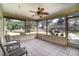 Relaxing screened porch with tiled floor, outdoor seating, and backyard views at 16036 3Rd St, Umatilla, FL 32784