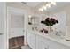 Bright bathroom featuring a double vanity, hardwood floors, and a doorway to the bathtub at 1727 Wood Violet Dr, Orlando, FL 32824