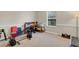 Exercise room with stationary bike, work out bench, and large window at 1727 Wood Violet Dr, Orlando, FL 32824