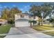 Two-story house with white exterior, a white garage door, and a palm tree in the front yard at 1727 Wood Violet Dr, Orlando, FL 32824