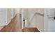 Hallway featuring neutral decor, hardwood floors, access to carpeted stairs, and a nearby linen closet at 1727 Wood Violet Dr, Orlando, FL 32824