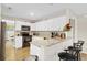 Well-lit kitchen with white cabinetry, granite countertops, modern appliances, and breakfast bar seating at 1727 Wood Violet Dr, Orlando, FL 32824