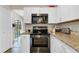 Updated kitchen with stainless steel oven and microwave complemented by granite countertops and white cabinets at 1727 Wood Violet Dr, Orlando, FL 32824