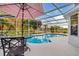 Screened-in pool features patio furniture and views of the landscaped backyard and lake at 1727 Wood Violet Dr, Orlando, FL 32824