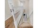 Bright staircase with white railing and wood floors, leading to carpeted steps at 1727 Wood Violet Dr, Orlando, FL 32824
