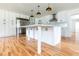 Stylish kitchen featuring white cabinets, a large island, and stainless steel appliances at 25335 Troon Ave, Sorrento, FL 32776