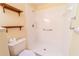 Clean bathroom with shower, toilet, and wooden shelves at 3934 Ne 21St Ln, Ocala, FL 34470