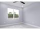 Bright bedroom with grey walls, ceiling fan, and large window at 39715 Royal Trails Road, Eustis, FL 32736