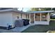 Exterior view of the home showing air conditioning units and other mechanicals adjacent to the enclosed porch at 4131 Yorketowne Rd, Orlando, FL 32812