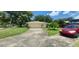 Detached garage and long driveway, surrounded by a lush lawn and mature trees at 4131 Yorketowne Rd, Orlando, FL 32812